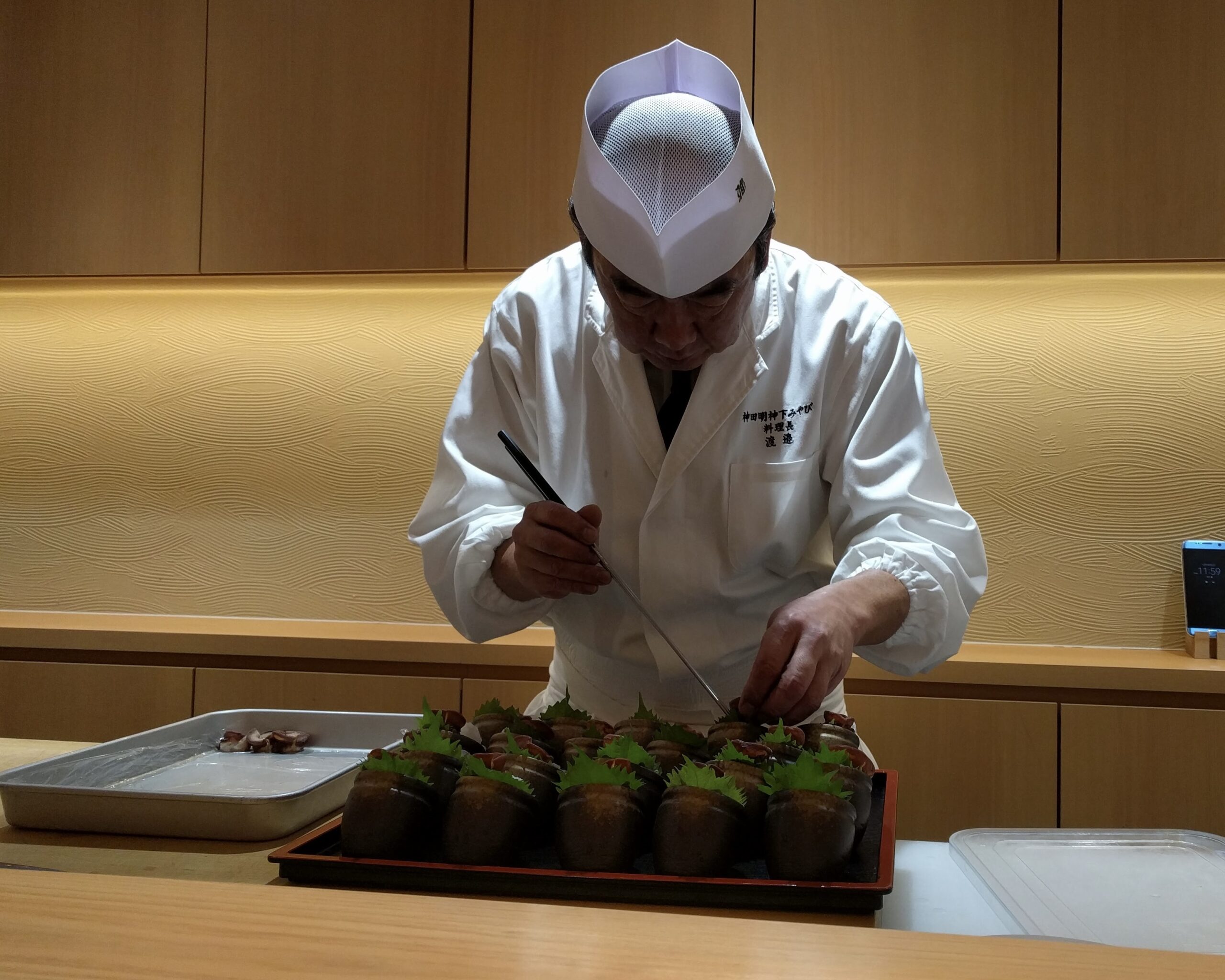 日本料理の職人が盛り付けを行う様子（京友会）